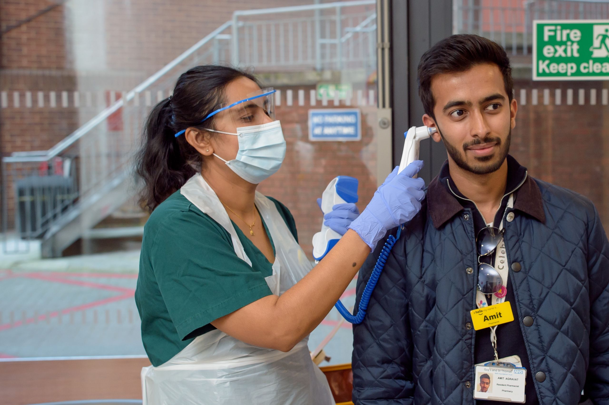 A dental nurse checking a staff member's temperature