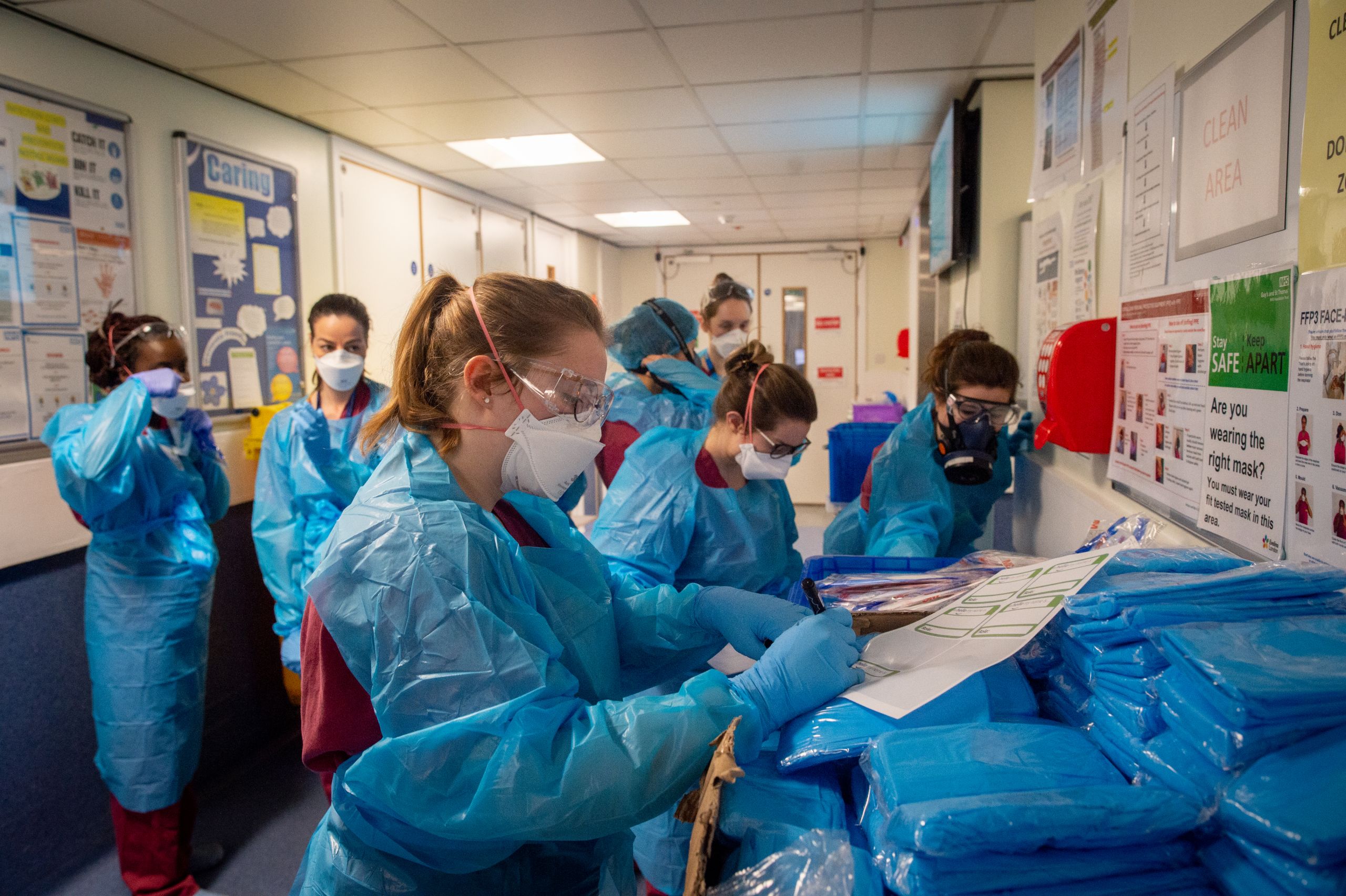 Critical care staff putting on PPE before a night shift